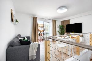 a living room with a couch and a tv at Liomor Luxury in Caleta De Fuste