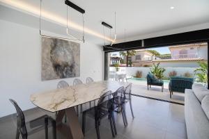 a dining room with a marble table and chairs at Lola Sea Villa in Novo Sancti Petri