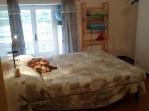 a stuffed teddy bear laying on a bed in a bedroom at Altrove - a due passi da Chiavari in Ne