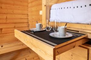 a table with two mugs and glasses on it at Les Chouchous du Garthieu in Hourtin