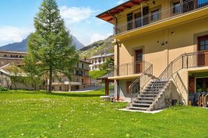 a building with stairs and a tree in a field at Alta Valle Maira C in Acceglio