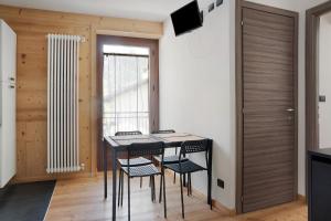 a dining room with a table and chairs and a window at Alta Valle Maira C in Acceglio