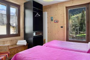 a bedroom with two beds and a window at Alta Valle Maira C in Acceglio