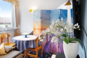 a living room with a vase of flowers on a table at Flair Ferienwohnung Lilie in Stockach +16 photos