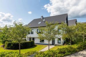a white house with a black roof at Ferienwohnung Viedenz in Drolshagen