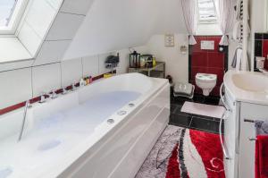 a bathroom with a large tub and a sink at Flair Ferienwohnung Lilie in Stockach