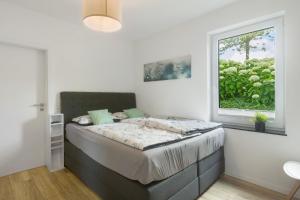 a bedroom with a large bed with a window at Ferienwohnung Viedenz in Drolshagen