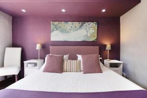 a bedroom with a large bed with purple walls at Los Veroles in Agaete