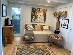 a bedroom with a bed and a painting on the wall at The G Shack at Rennies Beach in Ulladulla
