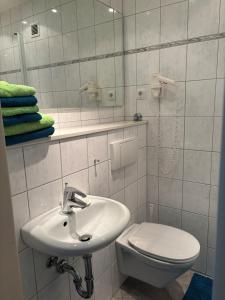 a bathroom with a sink and a toilet and a mirror at Apartment Dargies in Cuxhaven