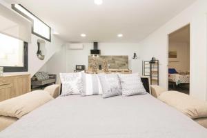 a bedroom with a large white bed with pillows at Apartamento Tom-Isi in Rota
