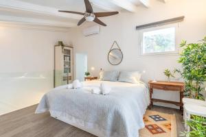a white bedroom with a bed and a ceiling fan at Casa La Bonita in Sóller