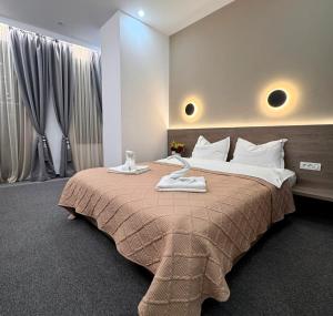 ein Schlafzimmer mit einem großen Bett, auf dem zwei Handtücher liegen in der Unterkunft Hotel Liad City Center in Bukarest + 180 Fotos