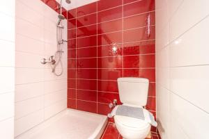 a bathroom with a toilet and a tub and red tiles at Arianna Studio Ground Floor 5 in Paleokastritsa +21 photos