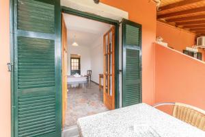 a room with green doors and a table and a room at Arianna Studio Ground Floor 5 in Paleokastritsa