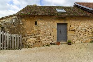 a stone building with a door and a fence at Chambres d'hôtes Exotique in Saint-Jory-las-Bloux +13 photos