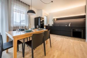 a kitchen and dining room with a table and chairs at Avia Living in Brunico