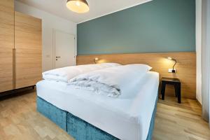 a bedroom with a large bed with white sheets at Avia Living in Brunico