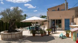 a patio with an umbrella and a pool at Ca na Rossa in Sineu