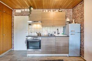 a kitchen with stainless steel appliances and a brick wall at Apartment Grundblick in Bad Grund +13 photos