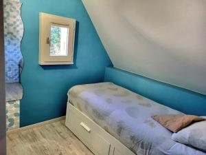 a small bedroom with a bed and a window at Jolie Maison Cyprange in Pirou