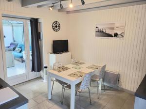 a dining room with a white table and chairs at Jolie Maison Cyprange in Pirou