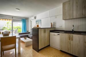 a kitchen with wooden cabinets and a living room at Brasil Mar in Playa de Gandia