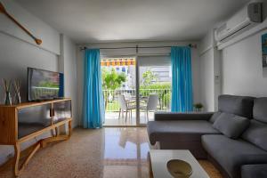 a living room with a couch and a television at Brasil Mar in Playa de Gandia