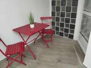 a red table with two chairs and a plant on it at Alojamiento Patricia in Igualeja +24 photos