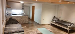 a living room with a couch and a kitchen at Käfer A in Waldbrunn