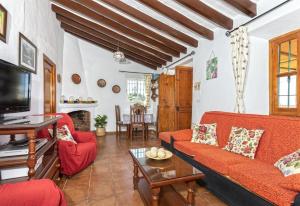 a living room with a red couch and a tv at El Puntal de Nieves in Nerja