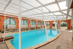 a swimming pool in a building with a roof at Finca Tropical in Ingenio