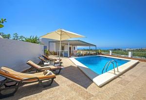 a swimming pool with lounge chairs and an umbrella at El Puntal de Nieves in Nerja