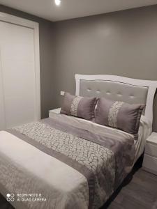 a bedroom with a large bed with purple pillows at Alojamiento Patricia in Igualeja