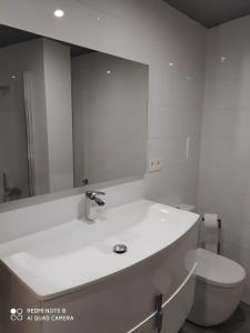 a white bathroom with a sink and a toilet at Alojamiento Patricia in Igualeja