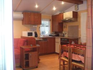 a kitchen with wooden cabinets and a kitchen with a couch at Mobilhome Topaze in Puget-sur-Argens