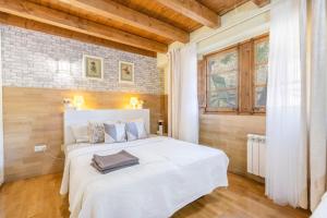 a bedroom with a white bed and a brick wall at Moli in Oden