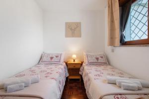 two twin beds in a room with a window at Maison Du Soleil - Bien-être in Saint Vincent