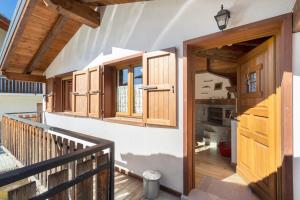 a hallway of a house with wooden doors andwindows at Maison du coeur - Bien-être in Challand Saint Anselme
