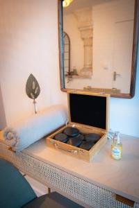 a mirror sitting on a table with a box of rocks at Couvent des Cordelières option spa in Vezins +26 photos