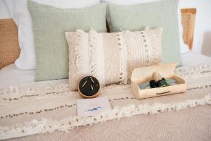 a clock sitting on top of a bed with pillows at Couvent des Cordelières option spa in Vezins