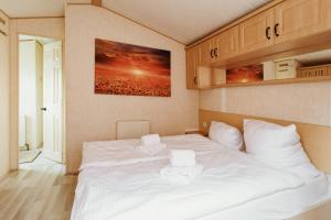 a bedroom with a white bed with two towels on it at Villa Hexenaltar in Thale