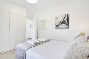 a white bedroom with a bed and white cabinets at Casa Mavadel in La Oliva