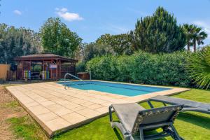 a swimming pool in a yard with a gazebo at Entre Viejos Olivos in Benicolet