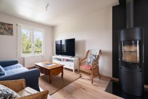 a living room with a couch and a tv at Gîte De L'enclume in Sévignac