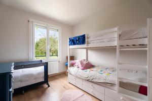 a bedroom with two bunk beds and a window at Gîte De L'enclume in Sévignac