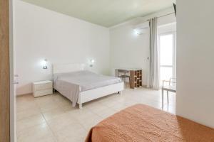 a white bedroom with a bed and a window at Villa Bludea - Salento in Torre Lapillo +58 photos