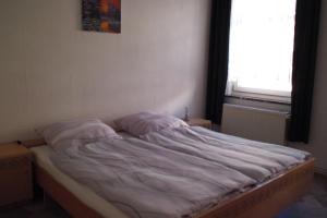 an unmade bed in a room with a window at Ferienwohnung Rose in Schöneck
