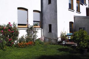 a building with windows and flowers in a yard at Ferienwohnung Rose in Schöneck