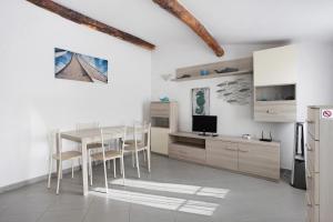 a white kitchen with a dining room table and chairs at Donadelmar2 in Riomaggiore
